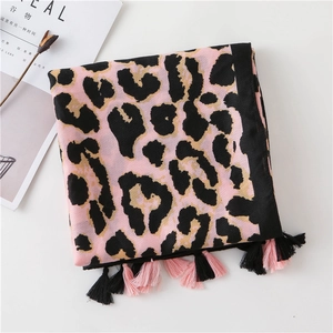 Detail of pink leopard print scarf with fringe tassels on white minimalist background