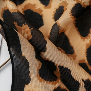 Detailed macro shot of leopard print scarf fabric showing fine texture and draped material