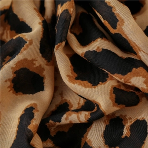 Macro view of leopard print scarf fabric showing detailed texture and soft cotton linen weave