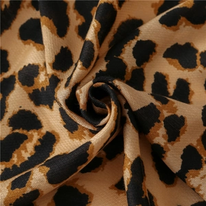 Detailed macro view of leopard print fabric texture with soft cotton-linen feel and fringe