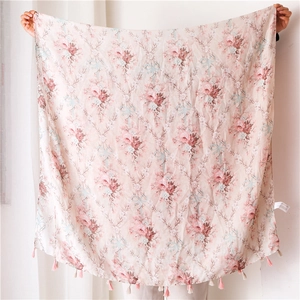 Close-up of floral cotton linen shawl with delicate pink and white fringe tassels