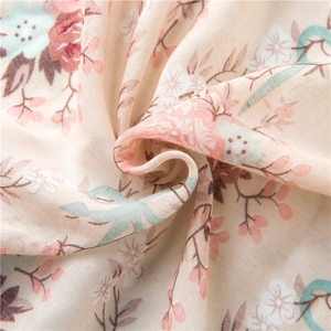 Close-up of floral print cotton linen scarf fabric with pink flowers and green leaves