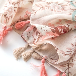 Close-up of lightweight floral cotton linen scarf with pink and khaki tassel details