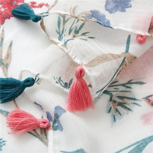 Detail of floral linen shawl with colorful tassels and breathable summer fabric weave