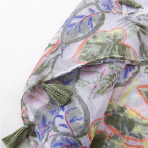 Detailed macro view of cotton linen fabric texture with green leaf print and tassels