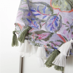Close-up of green leaf print on cotton linen scarf with soft fringe tassel detail