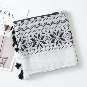 Macro detail of breathable cotton linen scarf with geometric pattern and long fringe trim