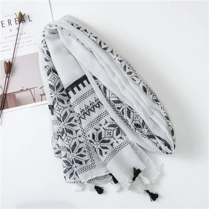 Close-up of geometric pattern scarf with black and white tassels on cotton linen fabric