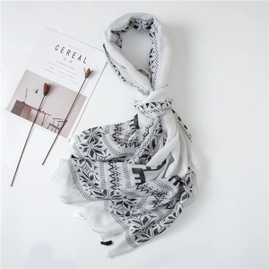 Detail view of white cotton linen scarf with black geometric ethnic patterns on white background