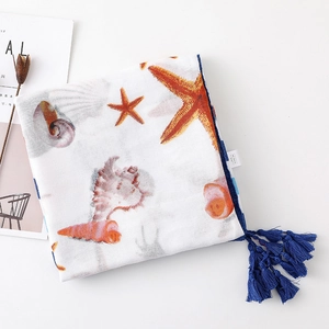 Detail of seashell and starfish print scarf with blue tassel edge and wash label