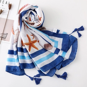 Detailed close-up of shell and starfish prints on blue striped linen scarf with tassels