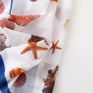 Detail of seashell and starfish print on white linen scarf with royal blue border