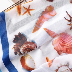 Detail shot of lightweight cotton linen scarf with orange starfish and shell prints