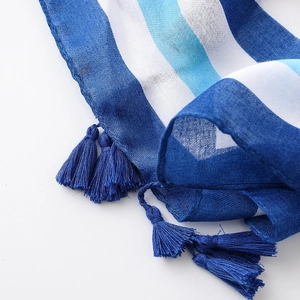 Detailed macro view showing blue cotton linen fabric texture and fringe tassels