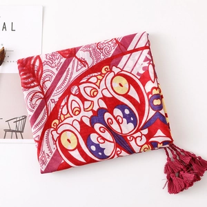 Close-up of red floral cotton linen shawl with ethnic patterns and fringe detail