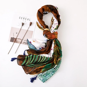 Détail d'une écharpe ethnique avec glands bleus et motifs géométriques boho