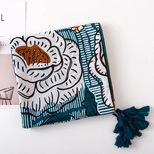 Detail of floral linen-feel scarf with deep cyan tassels and elegant flower print