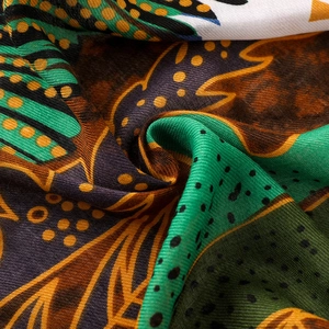 Détail macro du motif oiseau et fleurs sur écharpe en coton et lin au style ethnique