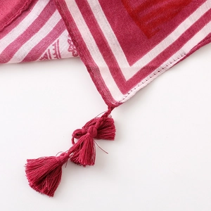 Detail of red and white striped shawl with intricate tassels and woven texture