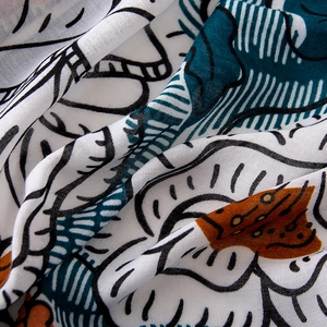 Detailed view of the soft cotton-linen fabric featuring elegant dark green leaf prints