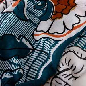 Macro detail of cotton-linen feel scarf showing vintage floral print and fabric texture