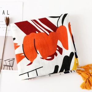 Détail d'une écharpe artistique abstraite aux motifs colorés et pompons jaune vif