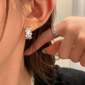 Elegant silver wave ear hoops with sparkling zircons worn by a female model