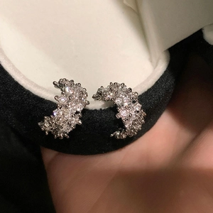 Elegant silver C-shaped hoop earrings with shimmering cubic zirconia on black velvet