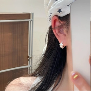 Elegant silver star earrings with white resin inlay worn by a female model in casual style