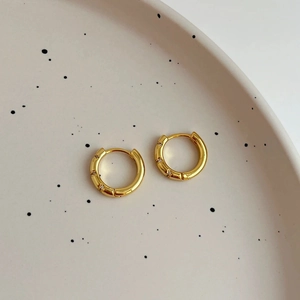 Créoles dorées minimalistes avec micro-incrustations de zircon sur plateau chic