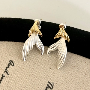 Close-up of elegant fishtail stud earrings with gold and silver two-tone brushed metal