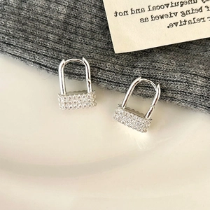 Close-up of vintage geometric door lock earrings with silver finish and micro-inlaid zircons