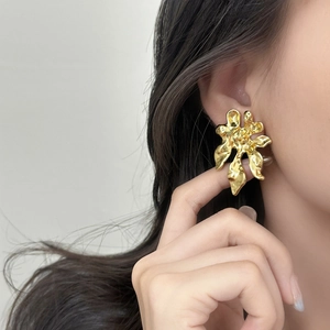 Exaggerated irregular golden flower stud earring with a glossy mirror lava metal texture