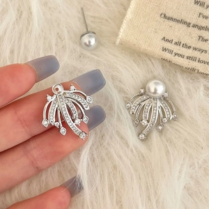 Detailed close-up of fireworks-style pearl earrings with silver cubic zirconia inlays