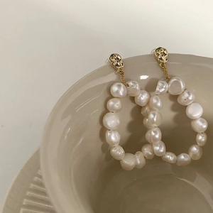 French vintage 18K gold plated baroque pearl hoop earrings on a ceramic display