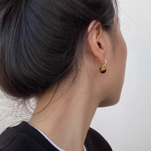 Detail of tiger eye stone drop earring on model showcasing natural brown texture and gold hook