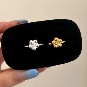 Elegant gold and silver flower rings set with sparkling cubic zirconia on black velvet