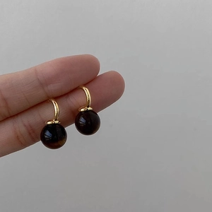 Minimalist golden metal hook earrings with round tiger eye stone charms for daily wear
