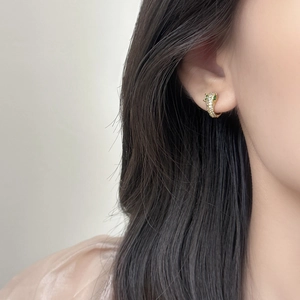 Boucles d'oreilles léopard dorées avec pavé de zircons blancs et yeux en gemmes vertes