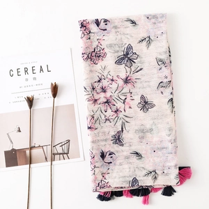 Pink floral cotton linen scarf with butterfly prints and tassels in a lifestyle setting