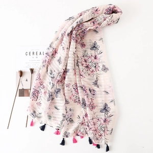 Detailed view of pink floral scarf with butterfly print and bicolor tassel edges