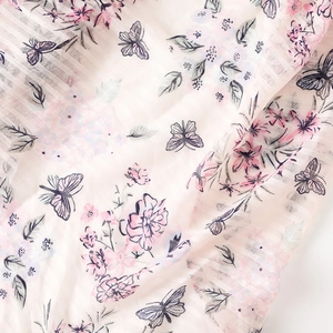Macro detail of cotton linen scarf showing pink flower clusters and butterfly prints