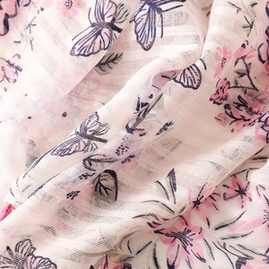 Detailed macro view of floral butterfly print on lightweight linen cotton scarf fabric