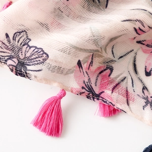 Detail of pink floral and butterfly prints on lightweight mesh scarf with tassel fringe