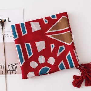 Détail d'une écharpe en coton et lin rouge avec motifs géométriques et franges