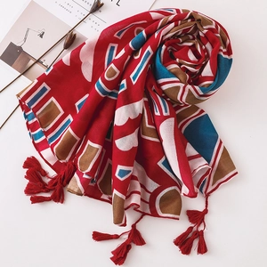 Détail de l'écharpe rouge en coton et lin avec imprimés géométriques et franges