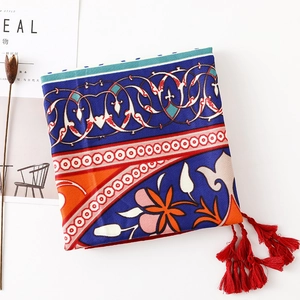 Detail of bohemian cotton linen scarf with ethnic patterns and vibrant red tassel fringe