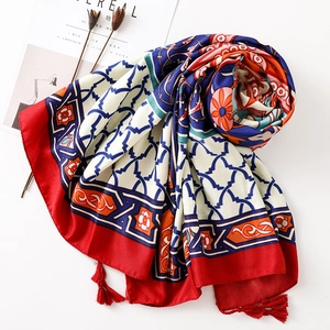 Macro view of Bohemian ethnic scarf featuring red tassels and geometric floral patterns