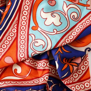 Close-up of silk scarf with ethnic paisley patterns and twill texture in vibrant colors