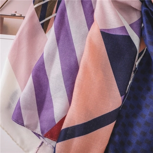 Close-up of geometric pattern scarf with abstract blocks, stripes and vibrant dots